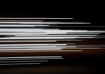 Abstract streaks of white and blue light blur across a dark background creating a sense of motion