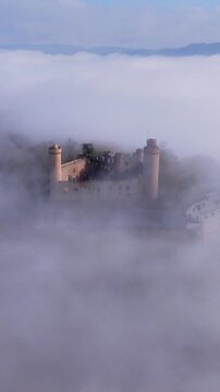 Aerial view of castle Auerbach enveloped in ethereal clouds, creating a dreamy, atmospheric scene with soft light, Bensheim, Hessen, Germany.
