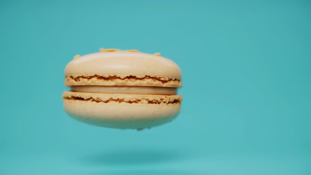 Light beige macaron floating against a teal background