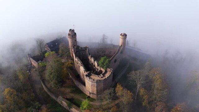 Aerial view of the medieval castle Auerbach in Bensheim, partially obscured by a thick fog, exuding a sense of mystery, Bensheim, Hessen, Germany.