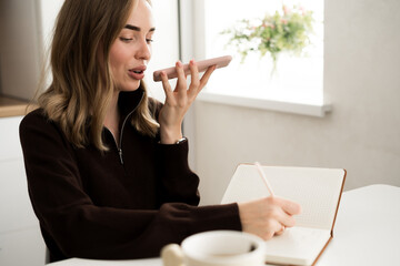 Technology, communication and people concept. Work From Home. Young woman talking on mobile phone...