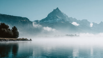 Serene mountain landscape with lake and morning mist. Calm water reflection of peak. quiet, atmospheric nature view for travel