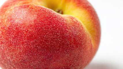 Vibrant close-up of a ripe, juicy peach showcasing its soft, fuzzy reddish-orange skin and healthy texture on a clean white background, symbolizing fresh summer fruit.