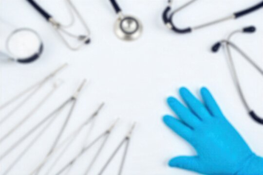 Maternity Doctor s Essential Tools A sterile, organized flat lay of medical instruments on a clean white surface with subtle blue accents. Include forceps, speculum, stethoscope, and nitrile gloves.