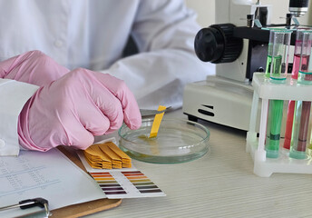 Scientist conducting tests on samples in a laboratory with a microscope and colorimetric analysis