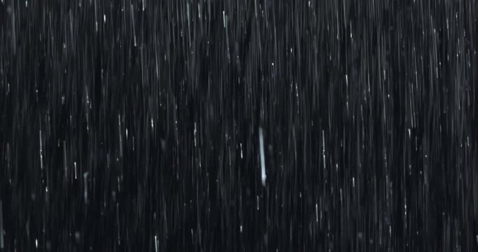 Intense wall of heavy rain falling against a black background, with close-up raindrops splashing on impact. A practical, seamless, loopable VFX element perfect for storm, drama, and atmosphere scenes.