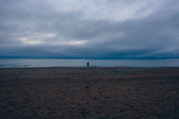 Reflections by the sea: silhouette against the clouds