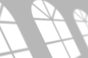 Soft window light casts elegant shadow patterns on a clean, modern background, perfect for design overlays.