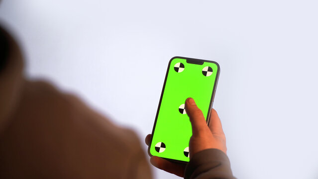 Green screen phone in hand for chroma key editing - Powered by Adobe