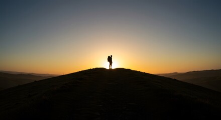 Silhouette of Hiker on Hill at Sunset with Golden Sky, Nature and Adventure
