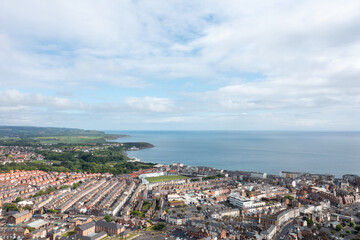 Aerial drone photo of the town centre of Scarborough North Yorkshire in the UK, showing the residential housing estates and historical town houses by the seaside going along to the beach front