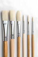 Row of artist paintbrushes close-up on white background