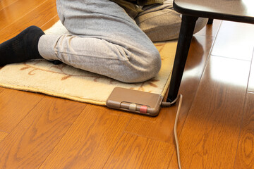 電気カーペットの上に座る