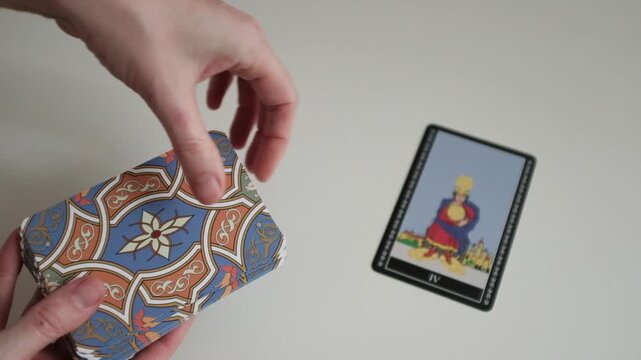A female astrologer holding and tossing a deck of tarot cards in her hands. 