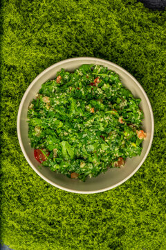 Tabbouleh salad. Middle eastern or arab dish. Levantine vegetarian salad with parsley, mint, bulgur, tomato. Vegan food. Top view mode of the salad. 