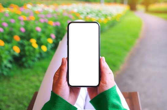 Mock Up smartphone with a blank screen in a garden with blooming flowers and greenery