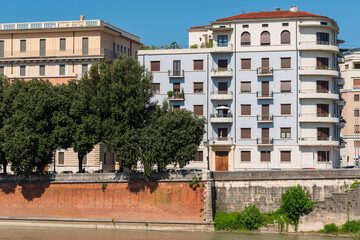 Picturesque view of buildings along a waterway in Verona, Italy. The image showcases the charm of Verona's urban architecture, with historic buildings featuring characteristic balconies and shutters