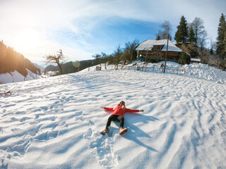 Happy girl lying down on fresh snow - Young woman having fun on high mountains during winter vacation - Holiday and travel concept - Focus on her body