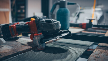Angle grinder on a workbench in a workshop setting, ready for use.