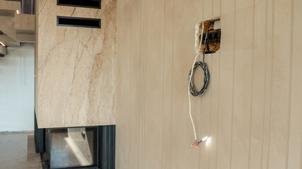 Modern fireplace with stone surround and electrical wiring during construction
