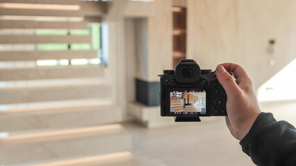 Photographer capturing modern interior staircase with digital camera