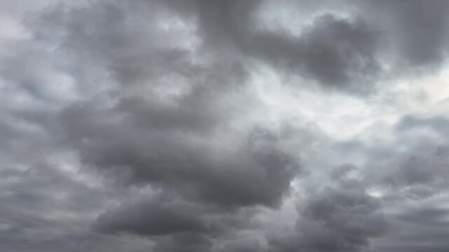 A timelapse of fluffy black clouds during stormy weather in winter. This footage captures dramatic winter conditions, showcasing the intensity of the storm. Dark cloud sky thunder storm cloud.
