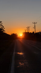 Car Driving on a Rural Road Toward the Setting Sun