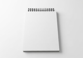 Blank spiral notebook open on a white background isolated on cream beige background
