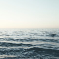 Obraz premium Calm ocean waves under a pale sky, serene water surface, peaceful nature background, tranquility.