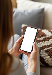 Woman using smartphone with blank white screen while relaxing on sofa at home showcasing mobile technology and connectivity for communication and entertainment