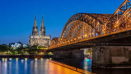 Cologne, Germany – April 25, 2025: Cologne Cathedral and Hohenzollern Bridge at Blue Hour, Cologne (Köln), Germany © majonit