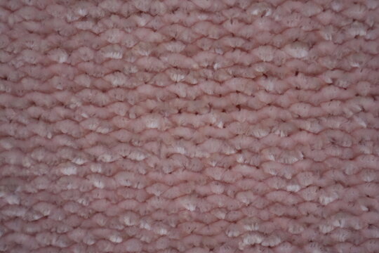 pink Soft plush fabric texture, close-up macro view of soft plush fabric with a warm, fuzzy surface. The detailed texture shows dense fibers and a gentle, velvety feel commonly used in blankets, cloth