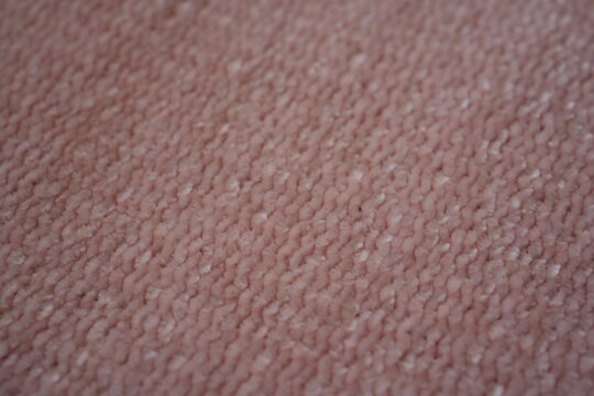 pink Soft plush fabric texture, close-up macro view of soft plush fabric with a warm, fuzzy surface. The detailed texture shows dense fibers and a gentle, velvety feel commonly used in blankets, cloth