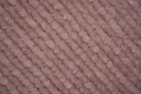 pink Soft plush fabric texture, close-up macro view of soft plush fabric with a warm, fuzzy surface. The detailed texture shows dense fibers and a gentle, velvety feel commonly used in blankets, cloth