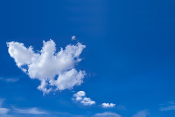 Background of fresh blue sky with free form white fluffy clouds. Image for meteorology presentation or inspiration concept.
