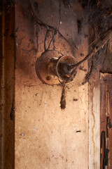 close-up of old electric fixture covered in cobwebs and dust, grimy wiring on stained wall, abandon...