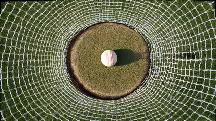 Overhead view of cricket batting tee and practice ball on grass, training aid equipment