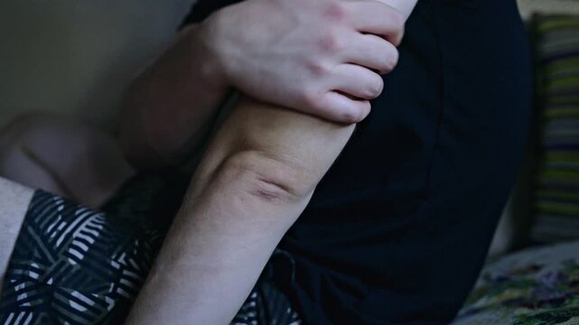 Close-up of a person gently massaging their elbow and arm, likely due to pain, injury, or to apply a soothing cream. The action conveys self-care, discomfort, or a form of self-treatment.