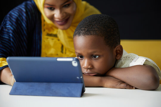 Muslim family, mother and son using a tablet on the table