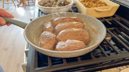Beef medallions cooking in hot skillet