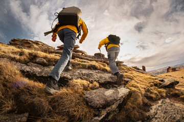 Two active male hikers guys goes uphill in mountains. Active tourism and hiking concept