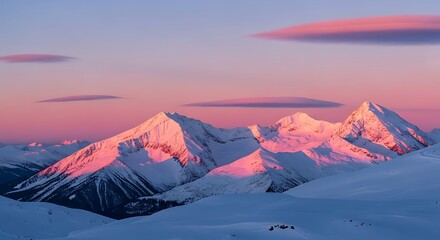 Majestic snow capped mountain peaks bathed in the warm soft glow of a vibrant sunset sky