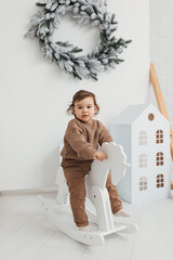 Little boy playing with toy horse. Child swinging on a rocking horse on a white background