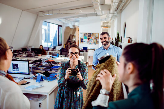 Young adults and adult man smiling during clothing photoshoot in fashion studio