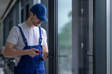 Craftsman installing hardware on glass door or partition