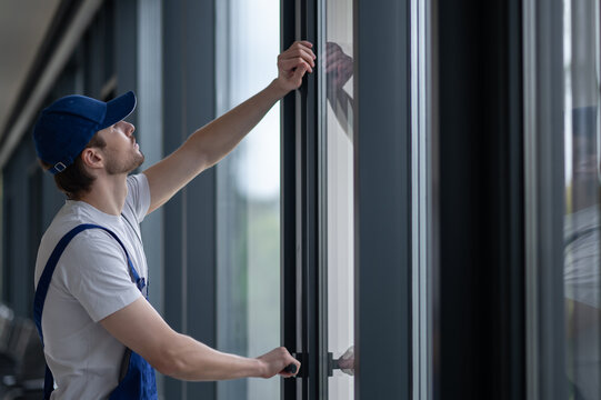 Male installer securing hinges and hardware on glass door