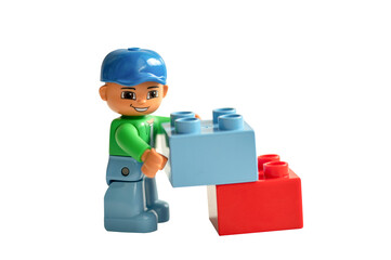 Naklejka premium Lego minifigure holds toy blocks isolated on a white background.