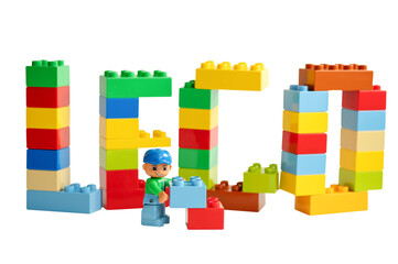 Naklejka premium A Lego minifigure holds toy blocks in front of the 