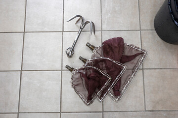 Fishing grappling hook and landing nets on floor