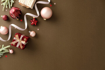 Flat lay of elegant Christmas decorations with ribbon on brown background